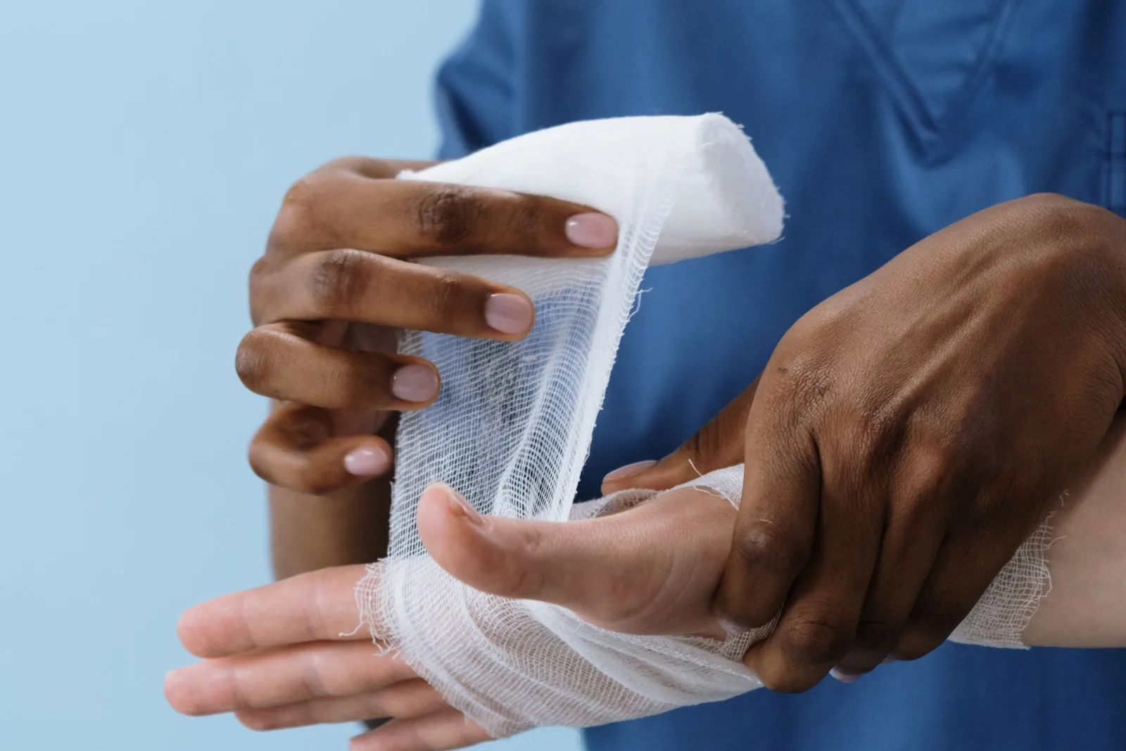 Burns expert witness — A clinician applying a gauze dressing to a hand