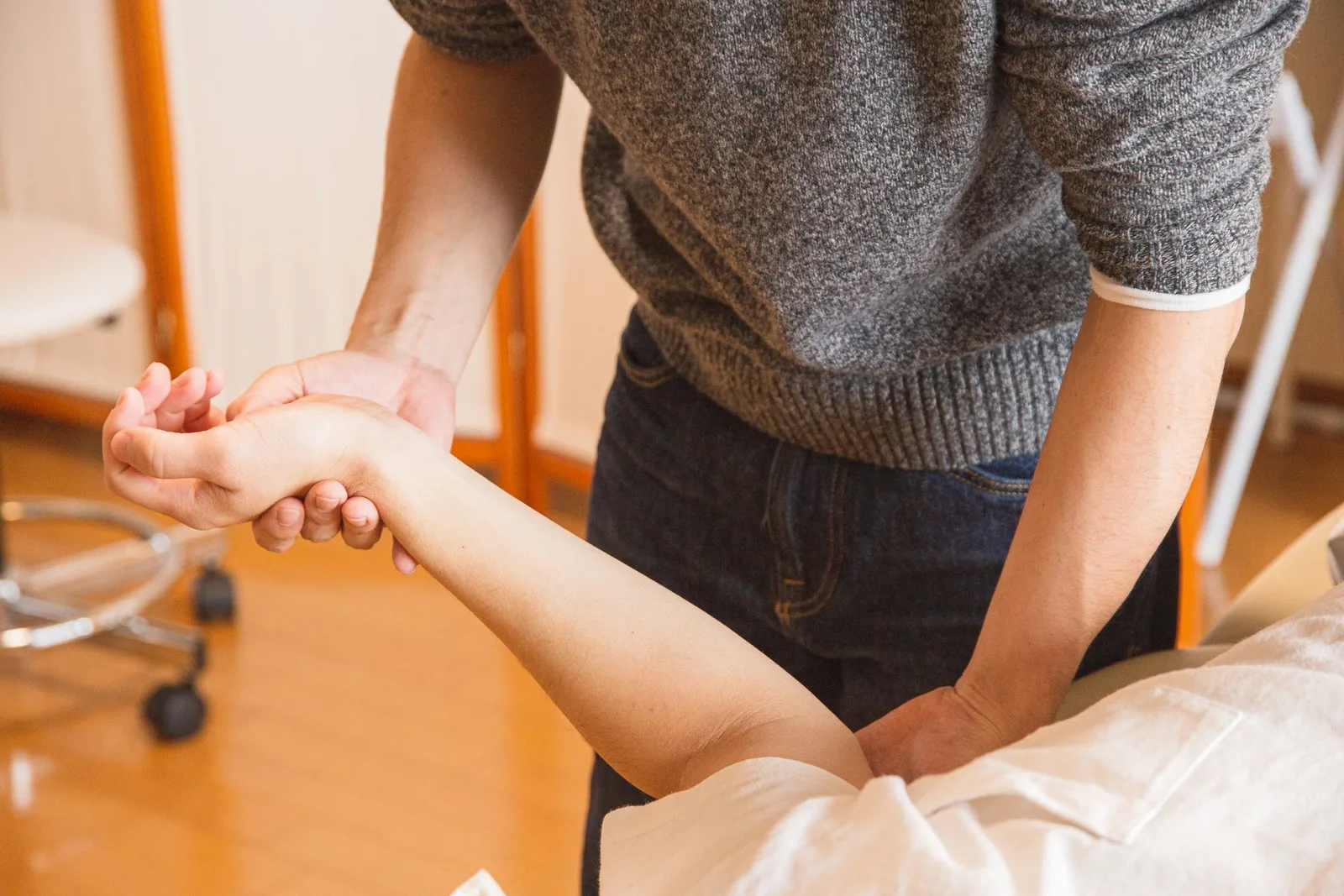 Chronic pain expert witness — Therapist assessing a patient's wrist and forearm