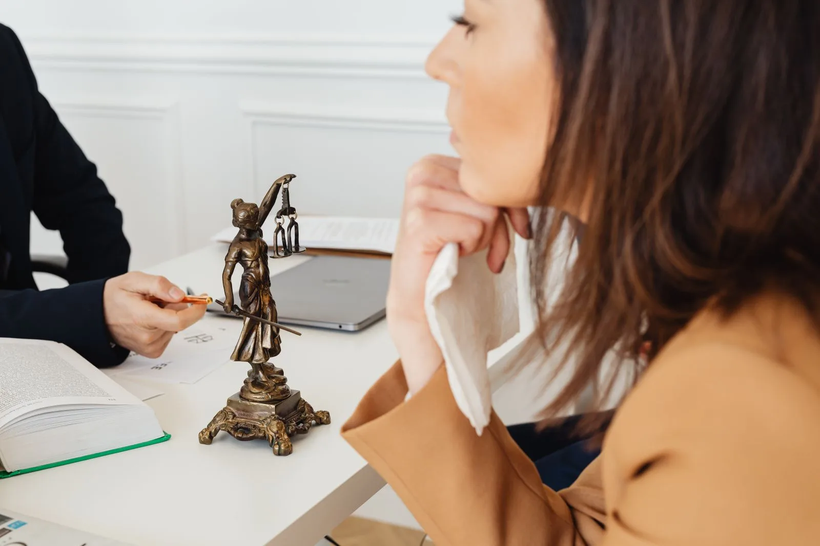 Criminal defence expert witness โ Solicitor advising a client, a figure of Justice on the desk