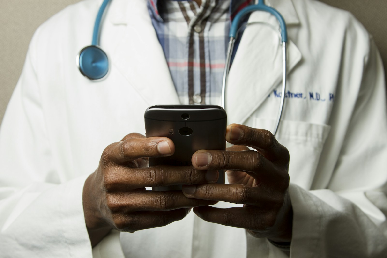 Medicine expert witness — Medical doctor reviewing a smartphone in clinic