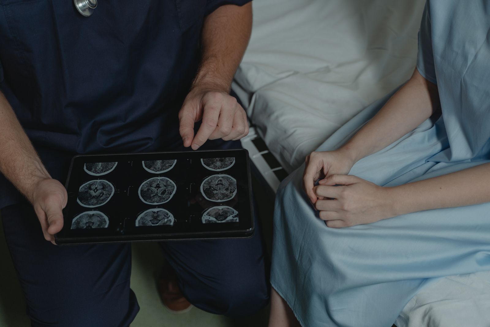 Clinician reviewing brain scan images with a patient, the evidence brain tumour expert witnesses interpret