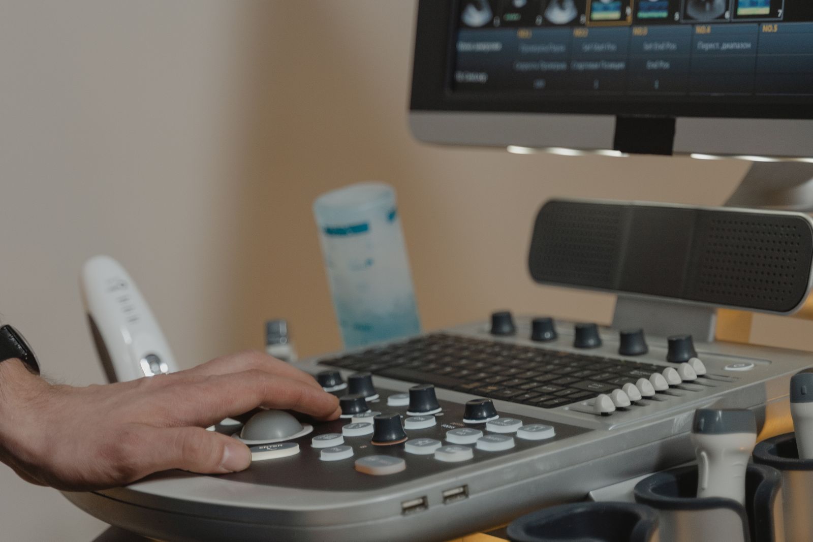Clinician operating an ultrasound console, the imaging hepatology expert witnesses review