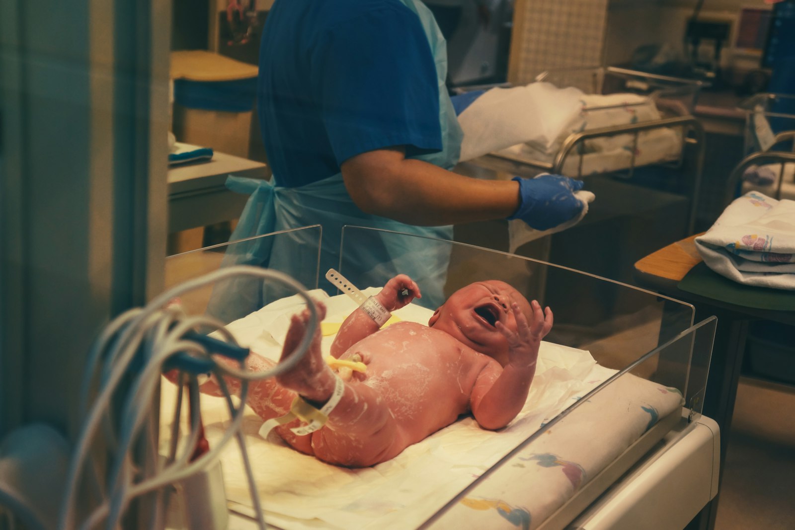 Midwife attending a newborn in a hospital cot, the care midwifery expert witnesses give evidence about