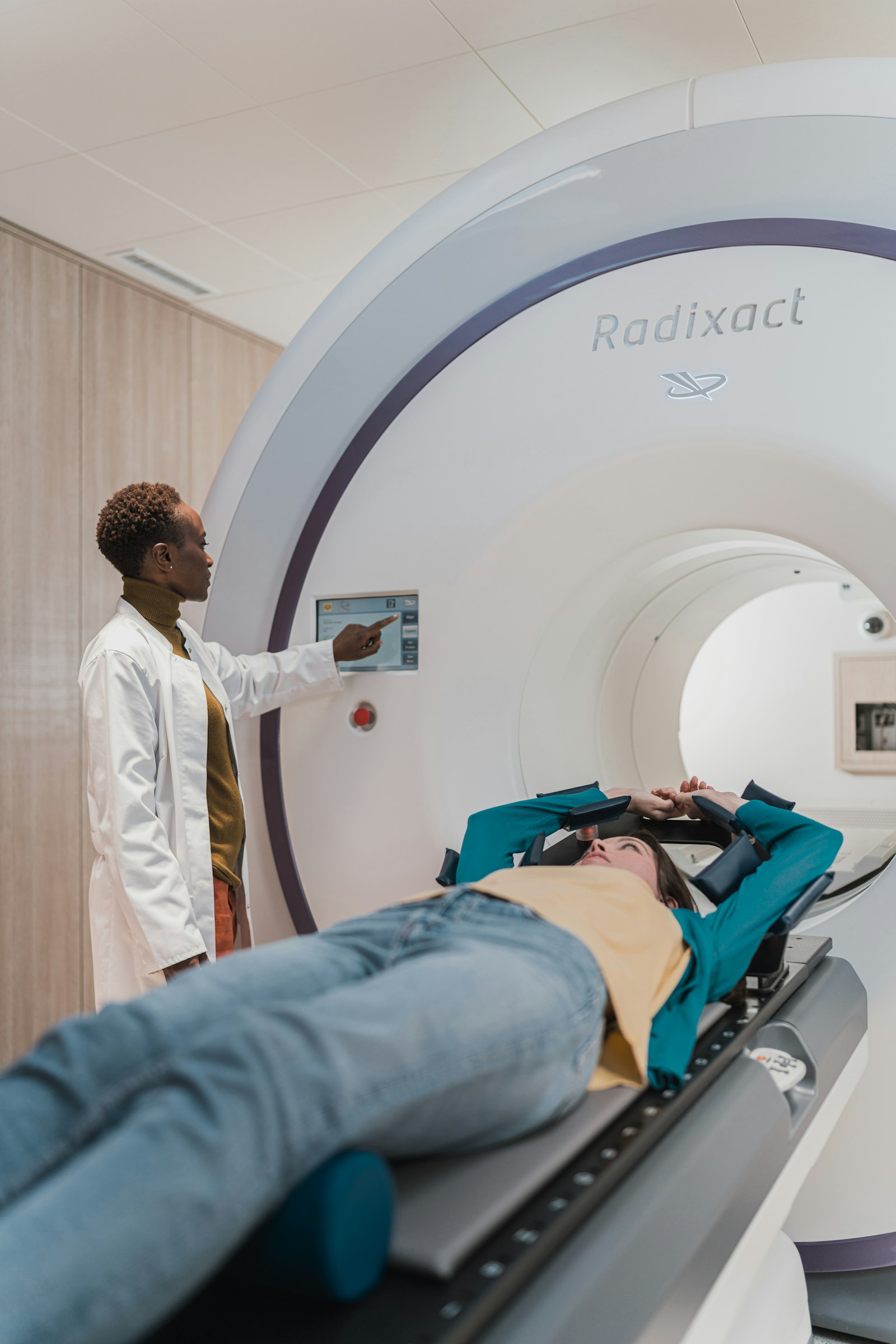 Expert witness report types — Clinician standing beside a patient undergoing a CT scan