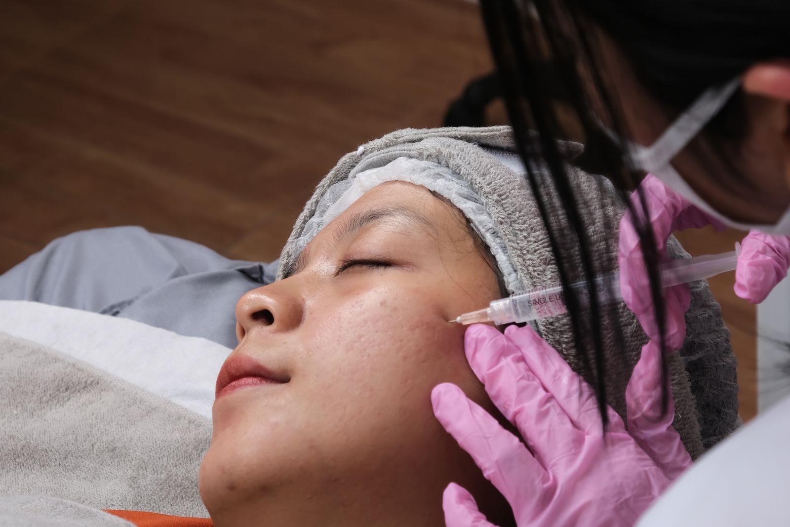 Practitioner administering a facial injection in a clinic, the practice aesthetic medicine expert witnesses assess