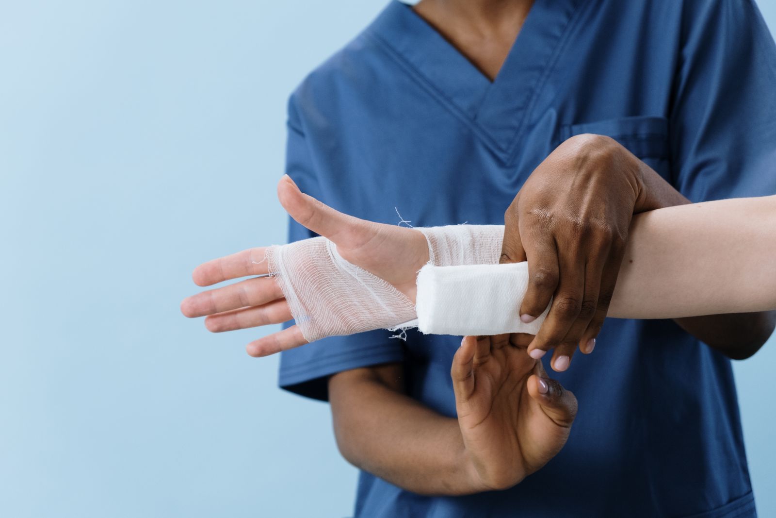 Clinician applying a dressing to an injured limb, the care burns surgery expert witnesses examine