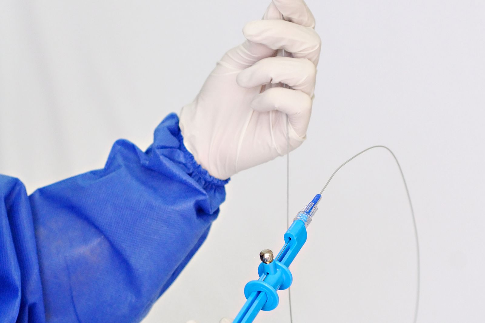 Gloved hands loading a guidewire into an endoscopic access device, the practice endo-urology expert witnesses examine