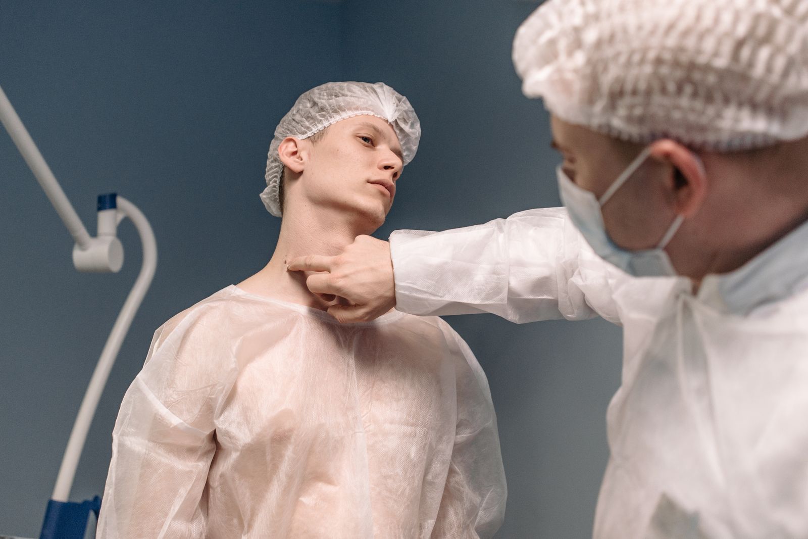 Clinician examining a patient’s neck in theatre, the assessment head and neck surgery expert witnesses undertake