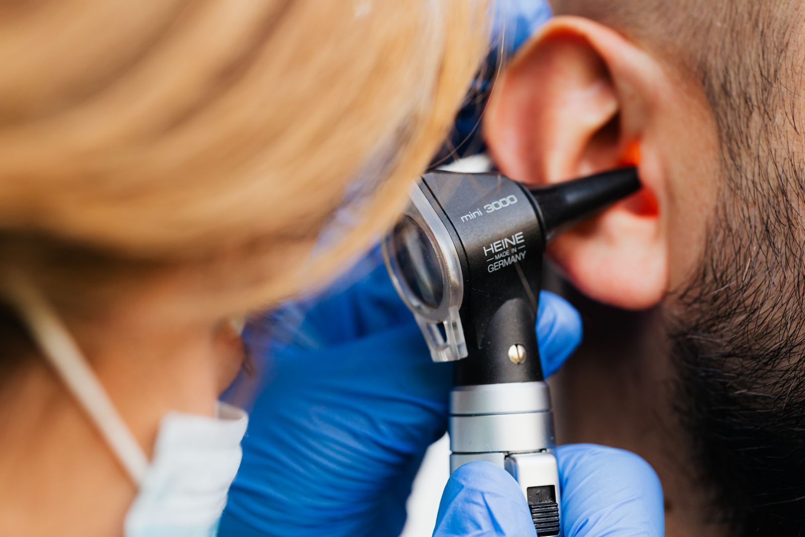 Clinician examining a patient’s ear with an otoscope, the assessment otology expert witnesses undertake