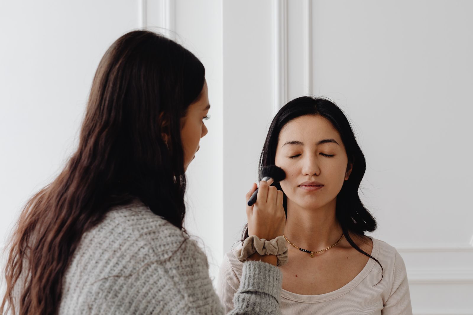 Practitioner applying camouflage cosmetics to a client’s face, the practice skin camouflage expert witnesses describe