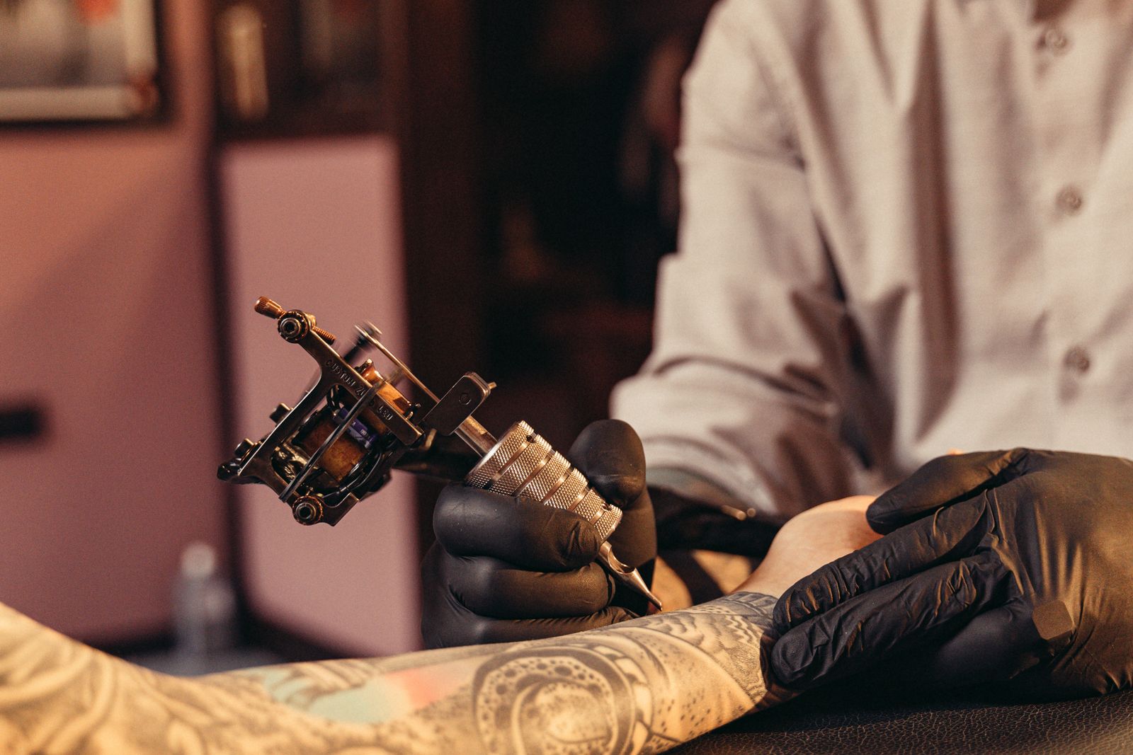 Tattoo artist working on a client’s arm in a studio, the practice tattoo expert witnesses describe